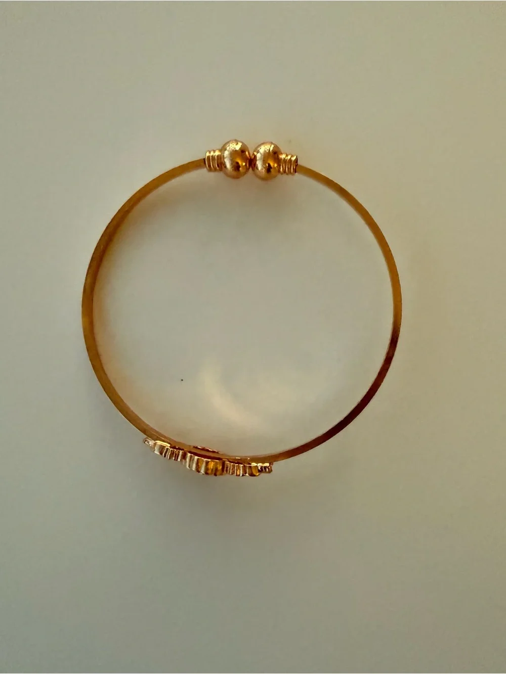 Gold bangle with red gemstone flower